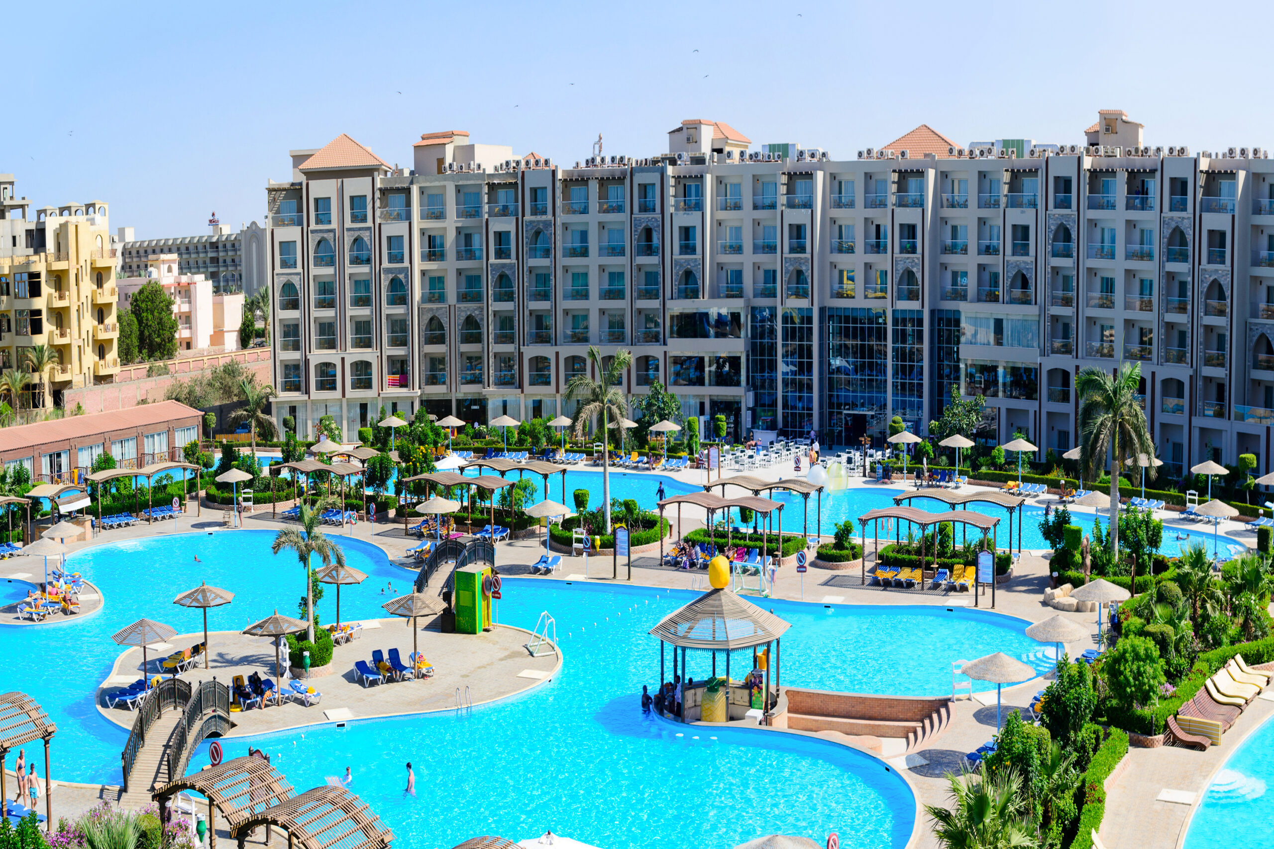 Home sharm el sheikh, egypt june 09, 2017: resort complex featuring multiple swimming pools, sunbeds, umbrellas and palm trees. luxury vacation and tourism concept.