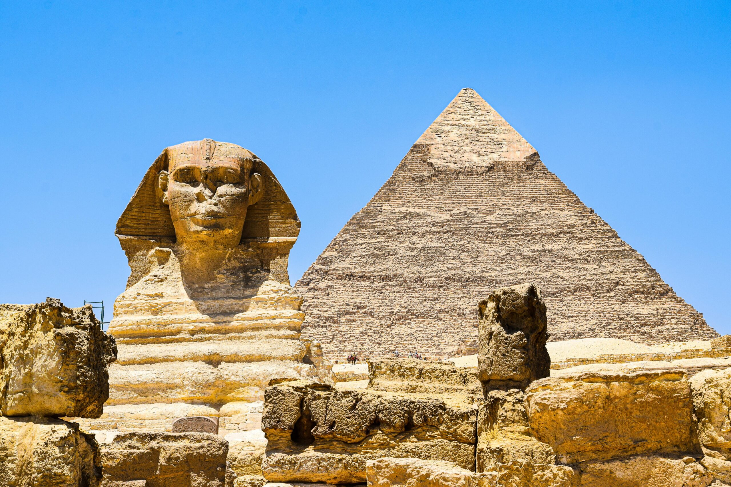 Magnificent view of the Great Sphinx and Pyramid of Khafre at Giza, Egypt under clear blue skies.